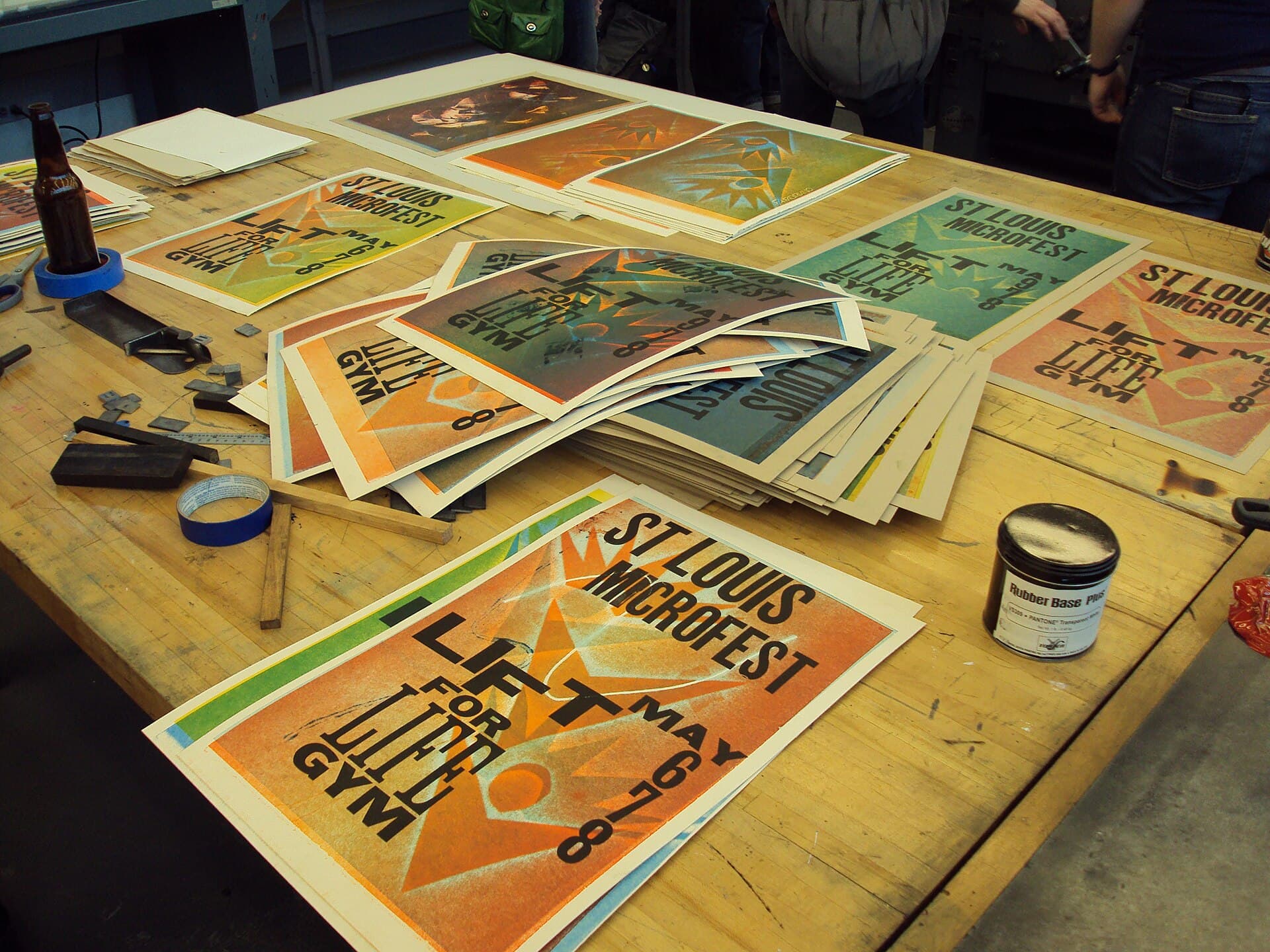 Colourful letterpress posters drying on a studio wall.